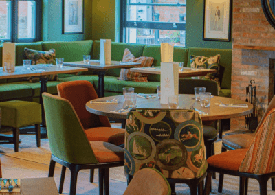 Interior of The Tap & Run pub in Upper Broughton, featuring bespoke bar stools, dining chairs, tables, curtains, and cushions to create a cricket-inspired atmosphere with hospitality furniture.